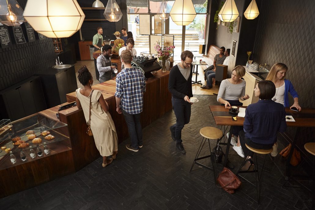 Popular modern coffee shop busy with customers and staff